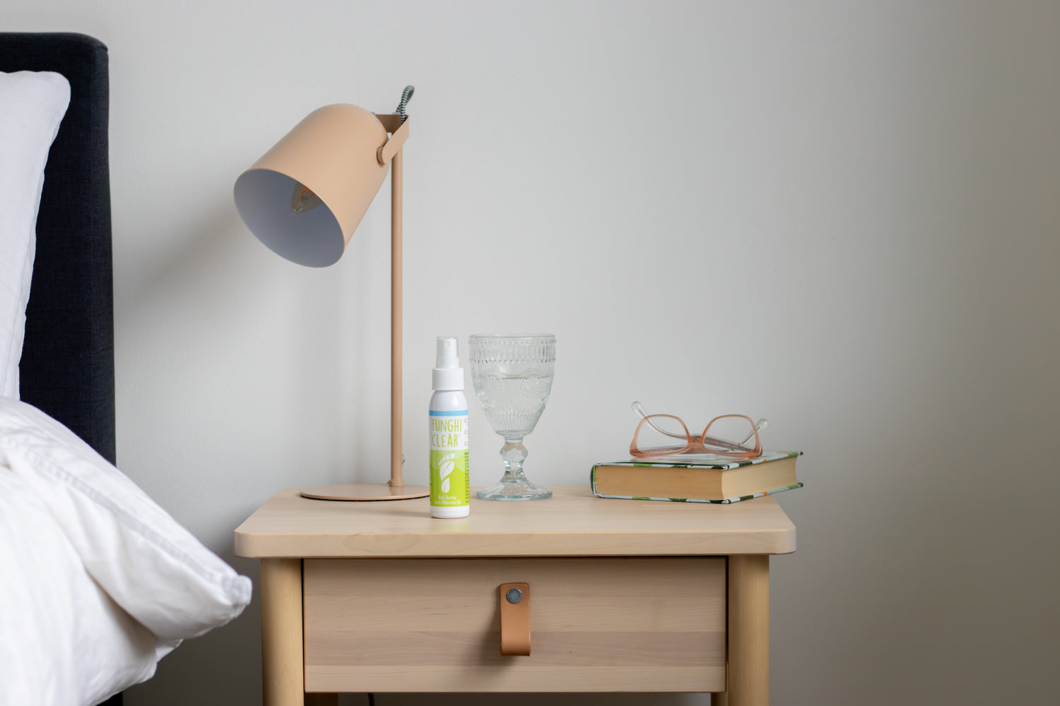 FunghiClear® nail spray on a bedside table, showing how it fits easily into a daily toenail fungus care routine